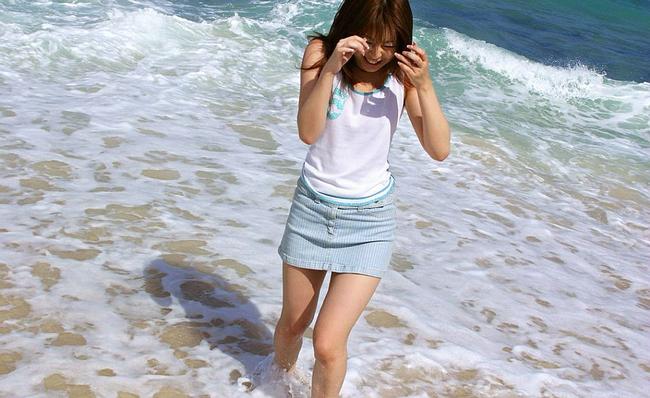 Девушка азиатка шалит на пляже 6 фото