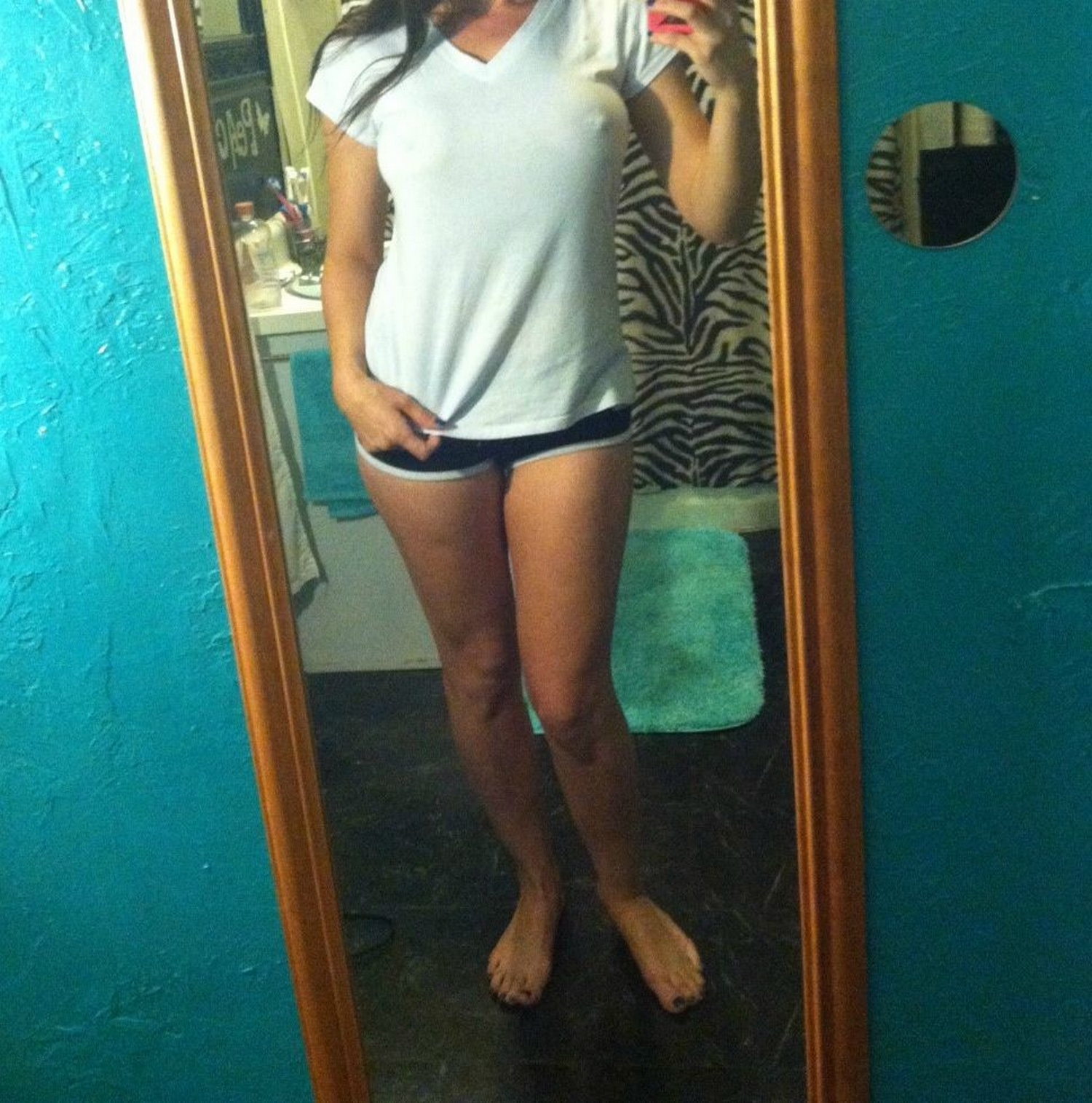 Спортивная девка позирует перед зеркалом без футболки 7 фото